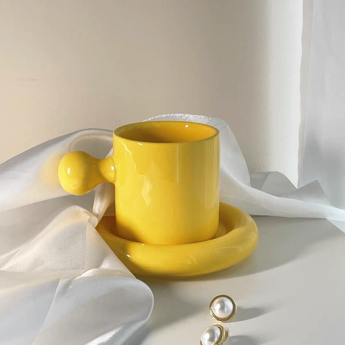 كوب قهوة بمسكه على شكل كره